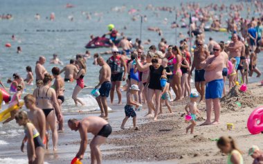SARBINOWO, BATI POLAND - 2021: Güneşli deniz plajında tatilciler yeniden yaratılıyor