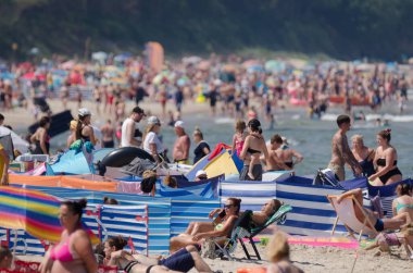 SARBINOWO, BATI POLAND - 2021: Güneşli deniz plajında tatilciler yeniden yaratılıyor