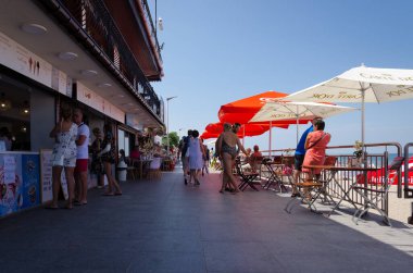 SARBINOWO, BATI POMERANYA / POLAND - 2021: Tatilciler gezinti güvertesi boyunca yürüyorlar 