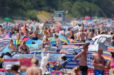 SARBINOWO, BATI POMERANYA / POLAND - 2021: Güneşli deniz plajında tatilciler yeniden yaratılıyor