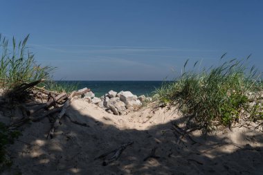 SEA Kıyı - Kum ve kayalar arka planda deniz olan kıyıları güçlendiriyor