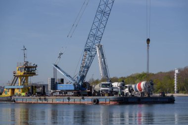 SUÇLU, Batı POMERANYAN - POLAND - 2022: Pusher ve yüzer platform, güvertede hidroteknik işler ve beton karıştırıcı kamyonlar için vinç