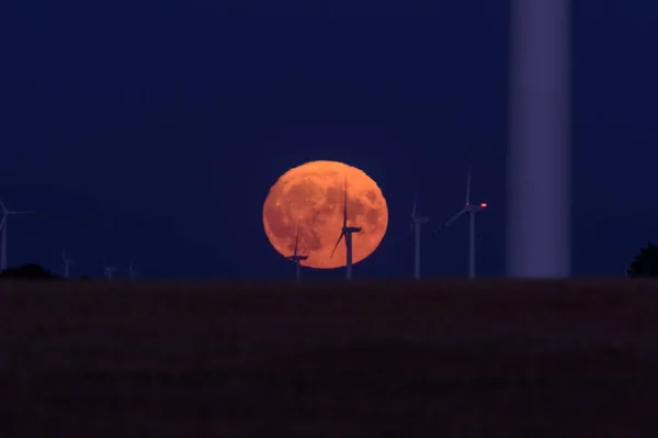 MOON - Earth satellite with wind farm turbines in the background