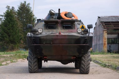 COMBAT RECONNAISSANCE-PATROL VEHICLE - A camouflage scout on a country road