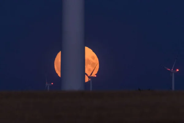 MOON - Earth satellite with wind farm turbines in the background