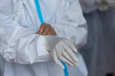 PPE giysisi olan doktor, nazal çubuk ile ATK test kiti kullanan bir test koronavirüsü (covid-19) kullanıyor..
