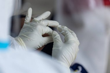 PPE giysisi olan doktor, nazal çubuk ile ATK test kiti kullanan bir test koronavirüsü (covid-19) kullanıyor..