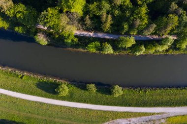 Thalkirchen, Münih 'te bir ormanın altındaki nehrin yanındaki yol. Hava aracı görüntüsü, kuş bakışı.
