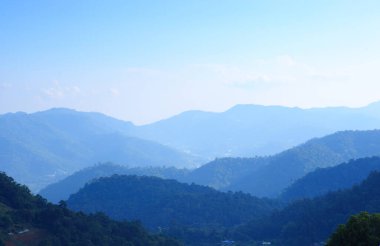 Görünür siluetlerle sabah sisli dağ sıraları. Romantik bir güneş ışığı anı.