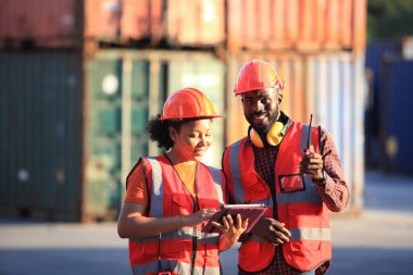 Afro-Amerikalı siyah mühendis lojistik taşımacılık ithalat veya nakliye endüstrisinin konteynır deposunda çalışıyorlar. 