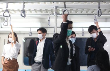 çeşitli yolcular metro vagonuna biniyor, trende maskeli insanlar.