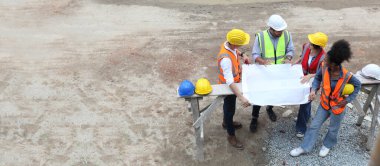 İnşaat sahasında, üst görünümde ve kopyalama alanında mühendislik veya işçi toplantısı tartışıldı