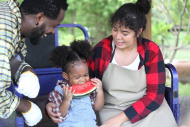 Afro-Amerikan ailesi mutlu ve kavun yiyor. 