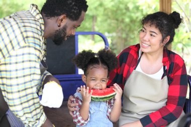 Afro-Amerikan ailesi mutlu ve kavun yiyor. 