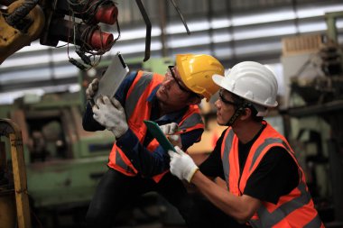 Makineli Endüstriyel Mühendisler. Endüstride üretim mühendisi. Endüstriyel fabrikadaki metal denetimini kontrol ediyor ya da zorluyor..