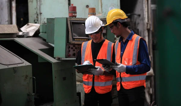 Industrial Engineers with machine.production engineer in industry. He checking or push metalwork control in industrial factory for  Concept Successful of Work.