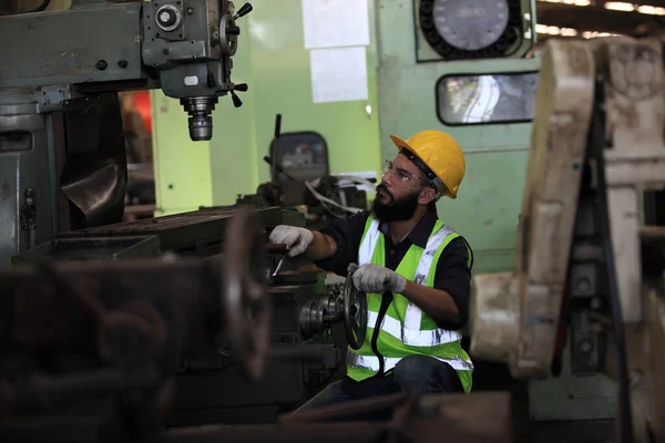 Industrial Engineers with machine.production engineer in industry. He checking or push metalwork control in industrial factory for  Concept Successful of Work.