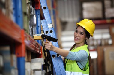 Depoda çalışan bir işçi. Kutuyu taramak ve yeni gelen malları analiz etmek için barkod tarayıcı kullanıyor. Depoda çalışıyorum. Uluslararası ihracat işi konsepti.