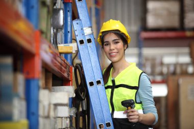 Depoda çalışan bir işçi. Kutuyu taramak ve yeni gelen malları analiz etmek için barkod tarayıcı kullanıyor. Depoda çalışıyorum. Uluslararası ihracat işi konsepti.