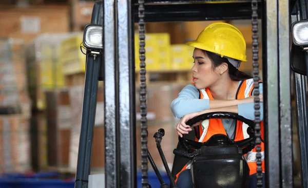 female driving forklift or Woman warehouse worker with forklift.worker in warehouse, Working at warehouse.International export business concept