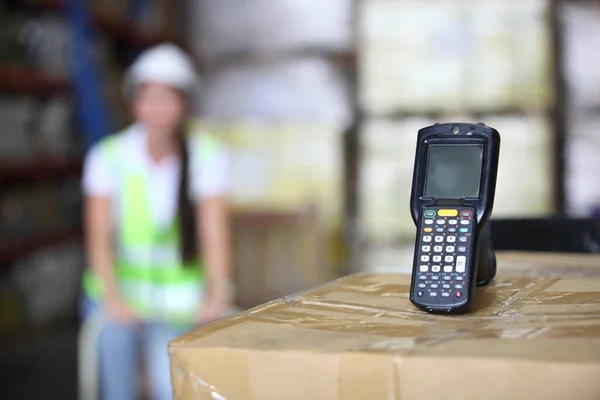 worker in warehouse,  using bar code scanner to scanning box and analyze newly arrived goods.  Working at warehouse.International export business concept