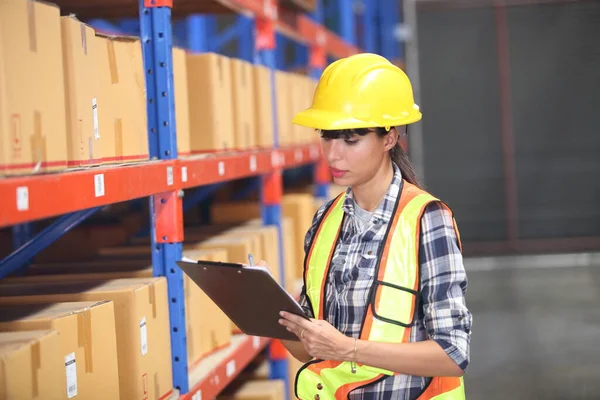 Portrait of female warehouse , she happy and  working at The Warehouse. Storehouse area, Shipment.  warehouse worker unloading pallet goods in warehouse