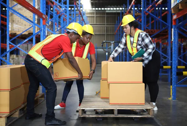 Warehouse worker working together in warehouse office Worker Moves Cardboard Boxes using Manual Pallet Truck, Warehouse. People Work in Product Distribution Logistics Center