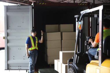 Depodaki forklift yükleyicisi. Dağıtım ürünleri. Teslimat. Lojistik. Ulaşım. İş geçmişi, depo işçisi, depo çalışanı. Uluslararası ihracat sektörü kavramı.