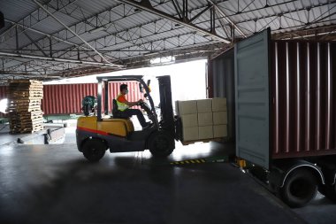 Depodaki forklift yükleyicisi. Dağıtım ürünleri. Teslimat. Lojistik. Ulaşım. İş geçmişi, depo işçisi, depo çalışanı. Uluslararası ihracat sektörü kavramı.