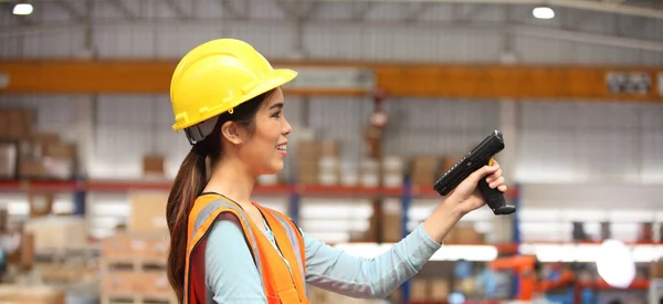 worker in warehouse,  using bar code scanner to scanning box and analyze newly arrived goods.  Working at warehouse.International export business concept