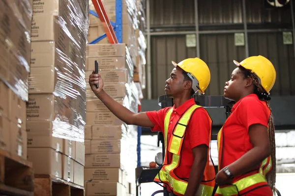 Portrait of worker in warehouse , they  happy and  working at The Warehouse. Storehouse area, Shipment.  warehouse worker unloading pallet goods in warehouse