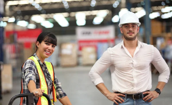 Portrait of worker in warehouse , they  happy and  working at The Warehouse. Storehouse area, Shipment.  warehouse worker unloading pallet goods in warehouse