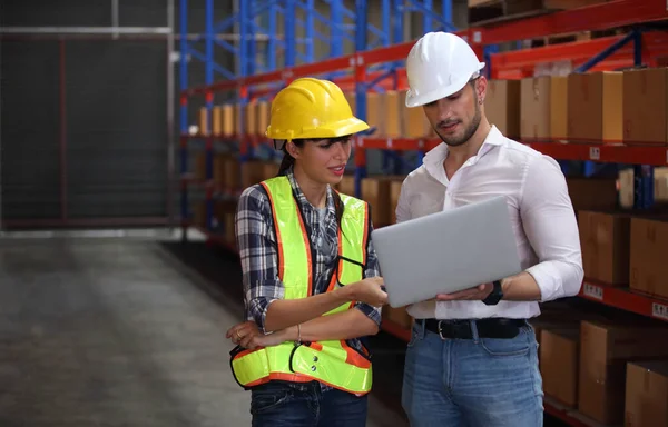 worker in warehouse,  using bar code scanner to scanning box and analyze newly arrived goods.  Working at warehouse.International export business concept