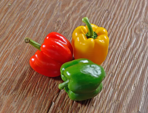 Sweet peppers on a wooden surface — Stock Photo, Image