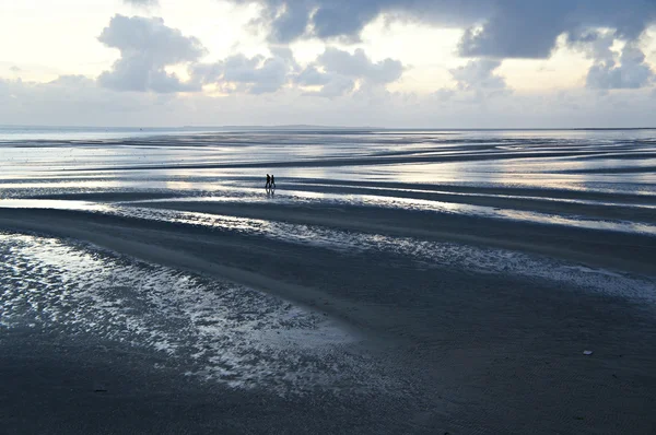 İki kişi bir kumsalda, gün batımı yürüyüş