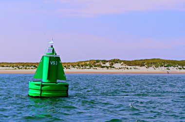 A green buoy in the Waddensea clipart