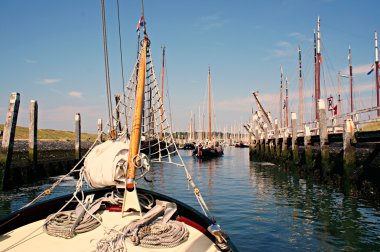 Traditional sailing yacht runs tidal harbor clipart