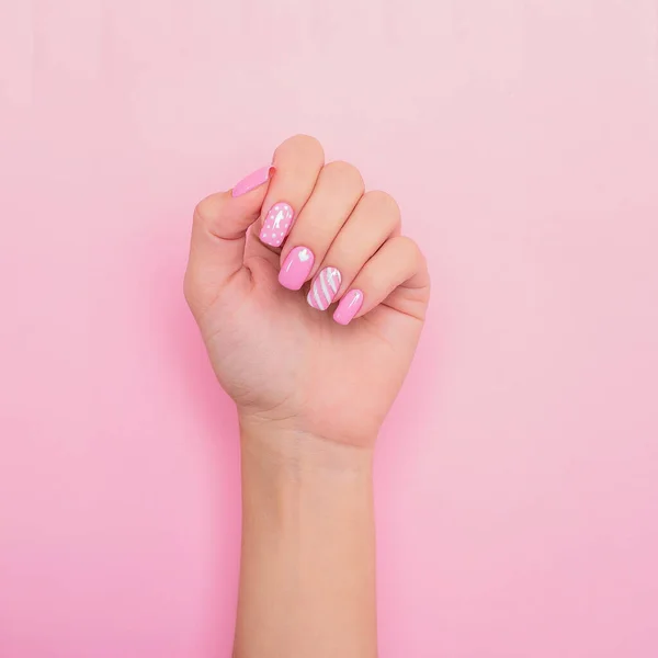 漂亮的女性手 有创意的指甲 心形图案 粉红背景 — 图库照片