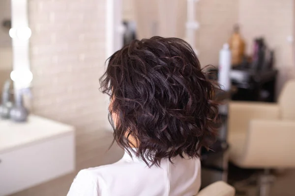 在美容院的背景上 美丽的黑发女人 留着短卷曲的发式 — 图库照片