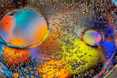 Parlak daireli soyut bir arka plan. Renkli bir görüntü, suyun üstünde yağ damlaları. Sıvı soyutlama. 