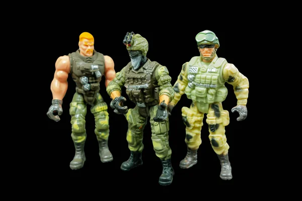 Toy model of a soldier on a black background. Three armed soldiers.