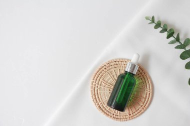 Tahta tabakta damla serumu. Beyaz kumaş arka planında doğal yüz yağı ya da serum ambalajı. Güzellik ürünleri markası maketi. Kozmetik cilt konsepti. en üstteki görünüm