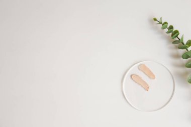 Kozmetik ürün için beyaz arka planda fotokopi alanı olan akrilik üzerine yumuşak bej makyaj temeli vuruşları