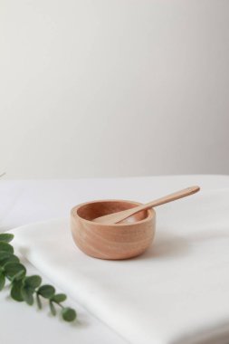 Kozmetik ürünler için ahşap küçük kase ve beyaz kumaş arka plan. Üst görünüm, boşluk kopyala.