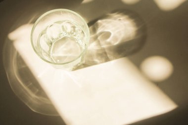 Beyaz arka planda parlak güneş ışığı gölgesi olan cam. Minimum lüks estetik konsept. maket ve arkaplan.