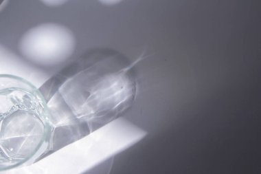 Beyaz arka planda parlak güneş ışığı gölgesi olan cam. Minimum lüks estetik konsept. maket ve arkaplan.