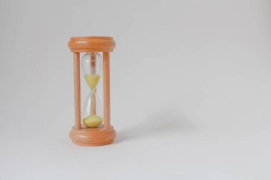 Kum saati ampullerinin arasından süzülen sarı kum, beyaz duvar arka planında fotokopi alanı, son teslim tarihine geri sayım zamanı. Çok az. vintage.
