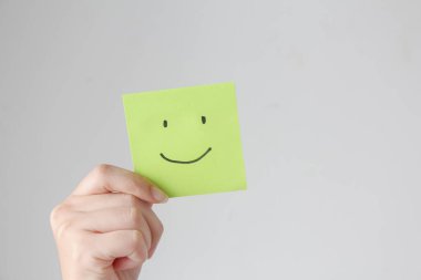 Yeşil gülücük kağıdı tutan kadın elleri, iyi geri bildirim notu, olumlu düşün, müşteri değerlendirmesi, değerlendirme, dünya ruh sağlığı günü, iltifat günü.