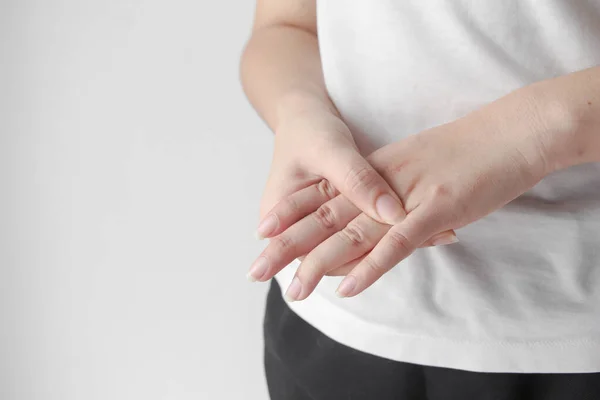 Young female suffering from pain in hands and massaging her painful hands. hurt include carpal tunnel syndrome, fractures, arthritis or trigger finger, Peripheral neuropathy.