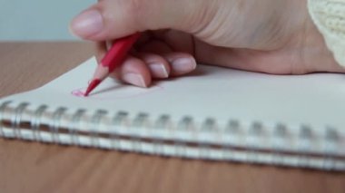 hand writing heart on notebook